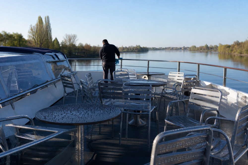 An open upper deck of a sightseeing cruise boat on the Seine in morning light, no text, no logos, no people