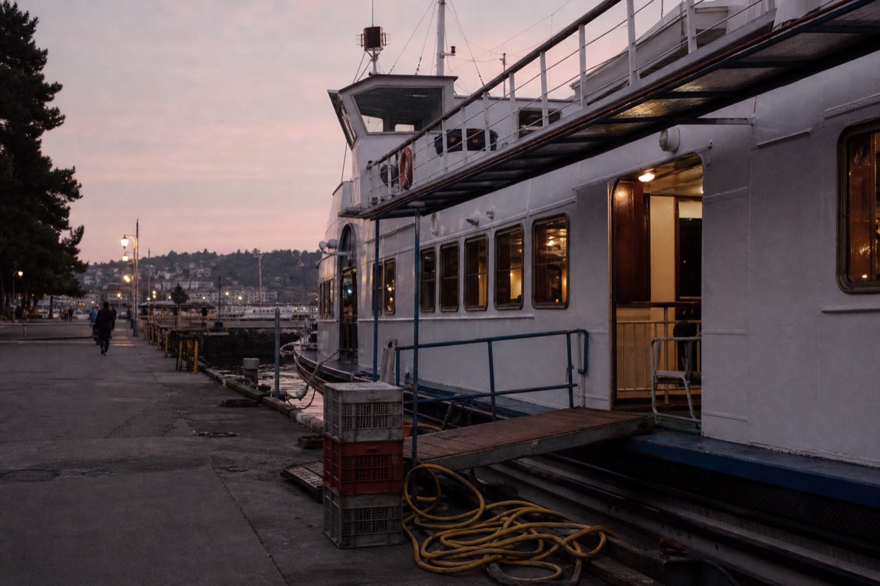 A Seine cruise boat moored at a Paris dock at dusk, no text, no logos, no people