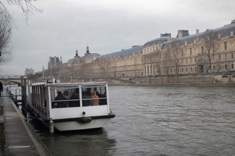 Batobus approaching a stop with the Louvre in the background, no text, no logos, no people