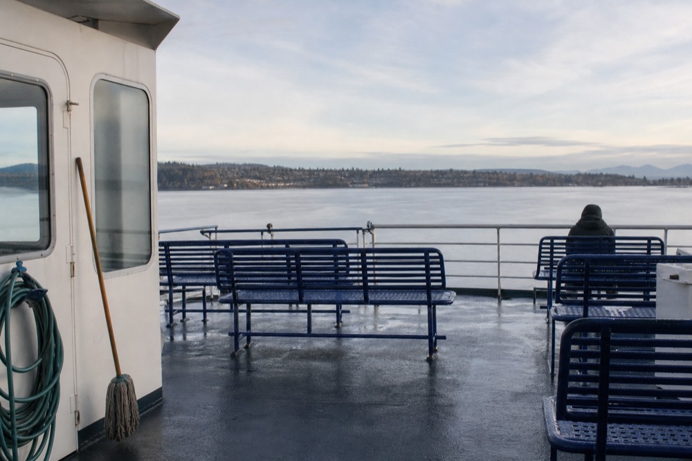 A cruise boat upper deck with empty railing seats in soft morning light on the Seine, no text, no logos, no people
