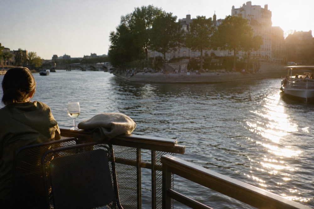Golden evening light on the Seine with a terrace cruise boat near Pont Neuf, no text, no logos, no people
