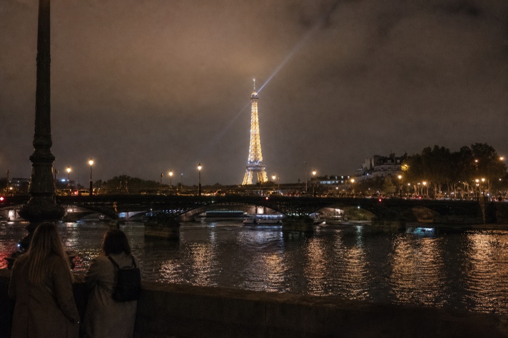 Eiffel Tower mid-sparkle seen from the Seine with lit bridges in the foreground, no text, no logos, no people