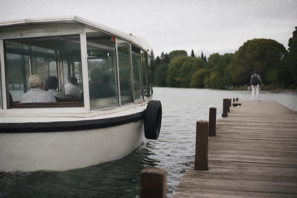 Glass-enclosed Batobus boat approaching a wooden Seine pontoon, no text, no logos, no people