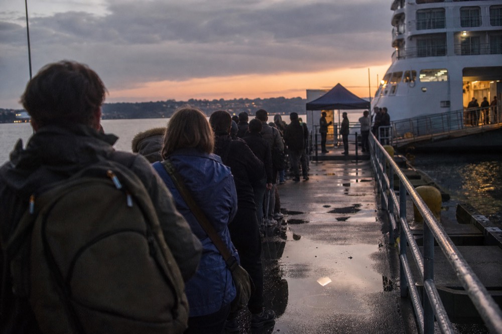 A boarding queue at a Seine cruise pontoon with staff checking tickets, no text, no logos, no people