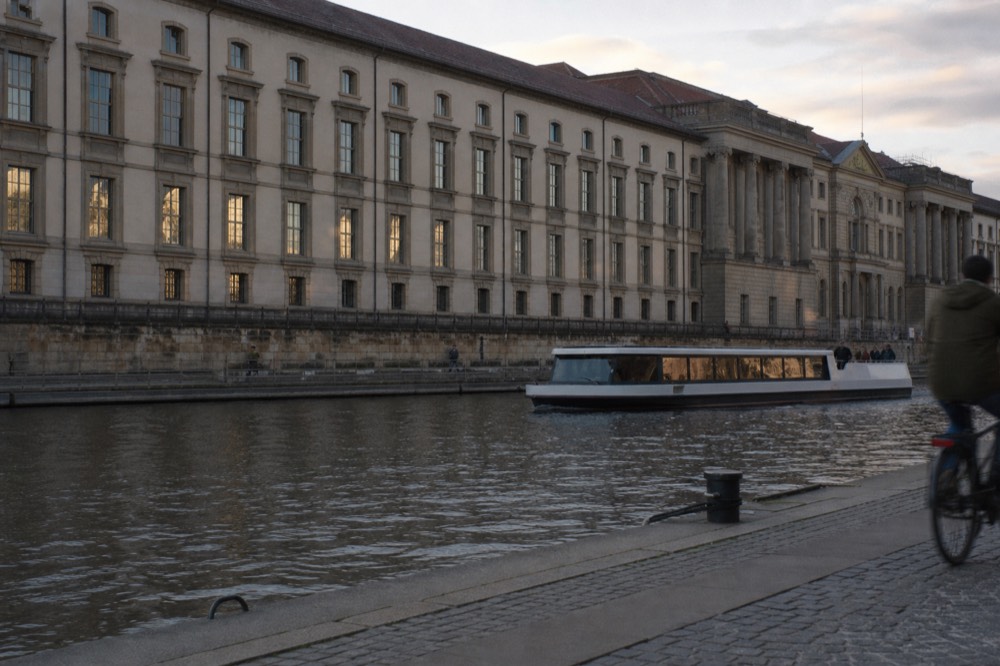 Electric passenger boat gliding quietly on the Seine past Parisian architecture, no text, no logos, no people
