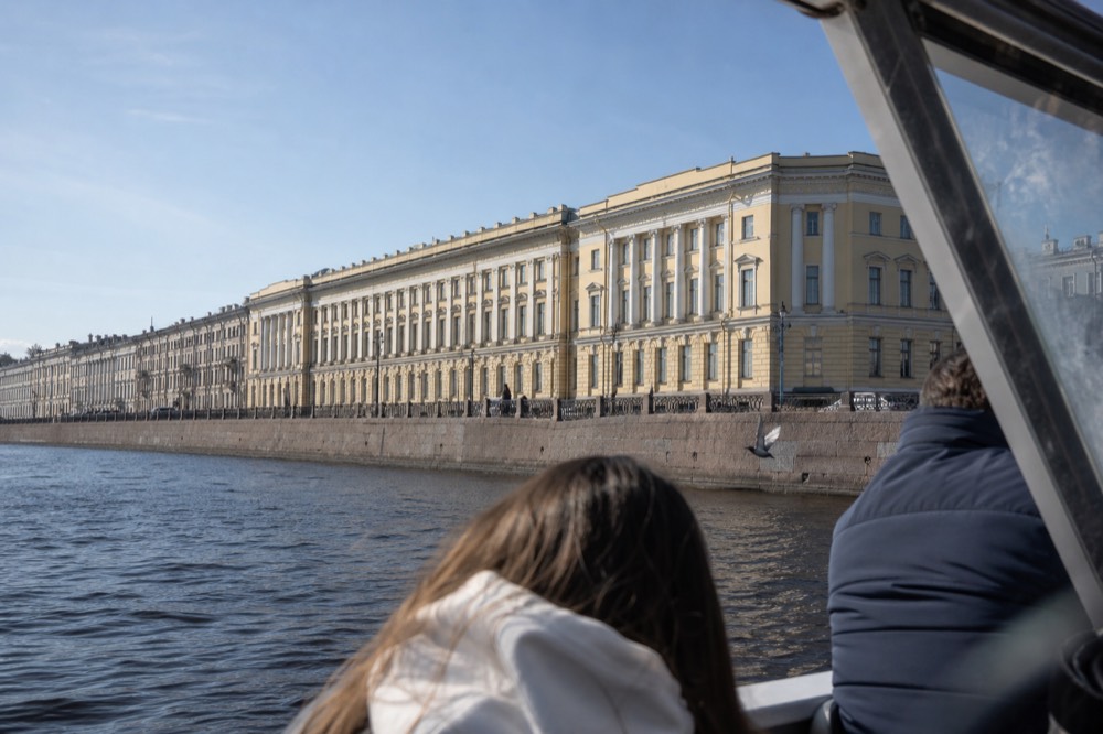 View from a boat deck toward the Louvre riverside wing on the Seine, no text, no logos, no people