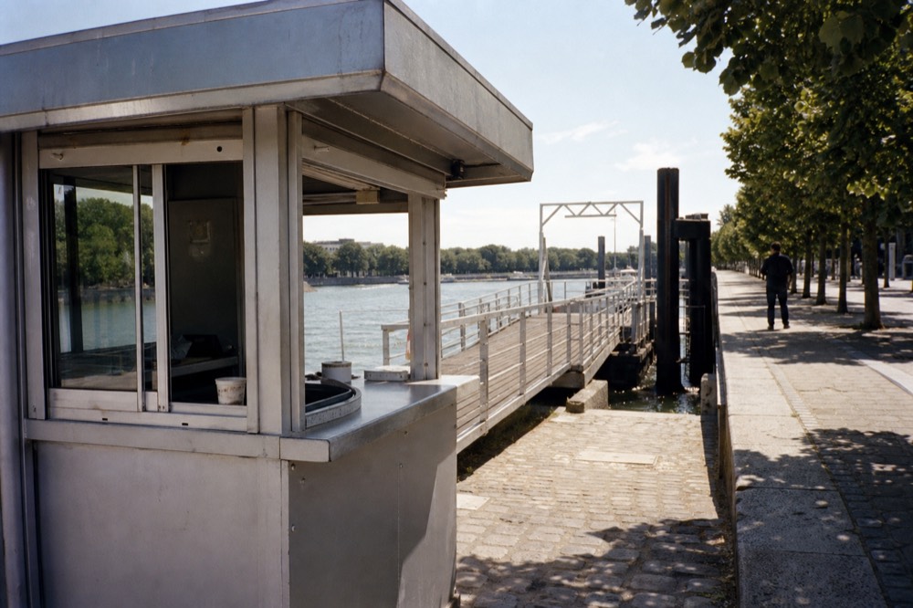 Ticket booth and boarding pontoon at a Seine cruise dock in central Paris, no text, no logos, no people