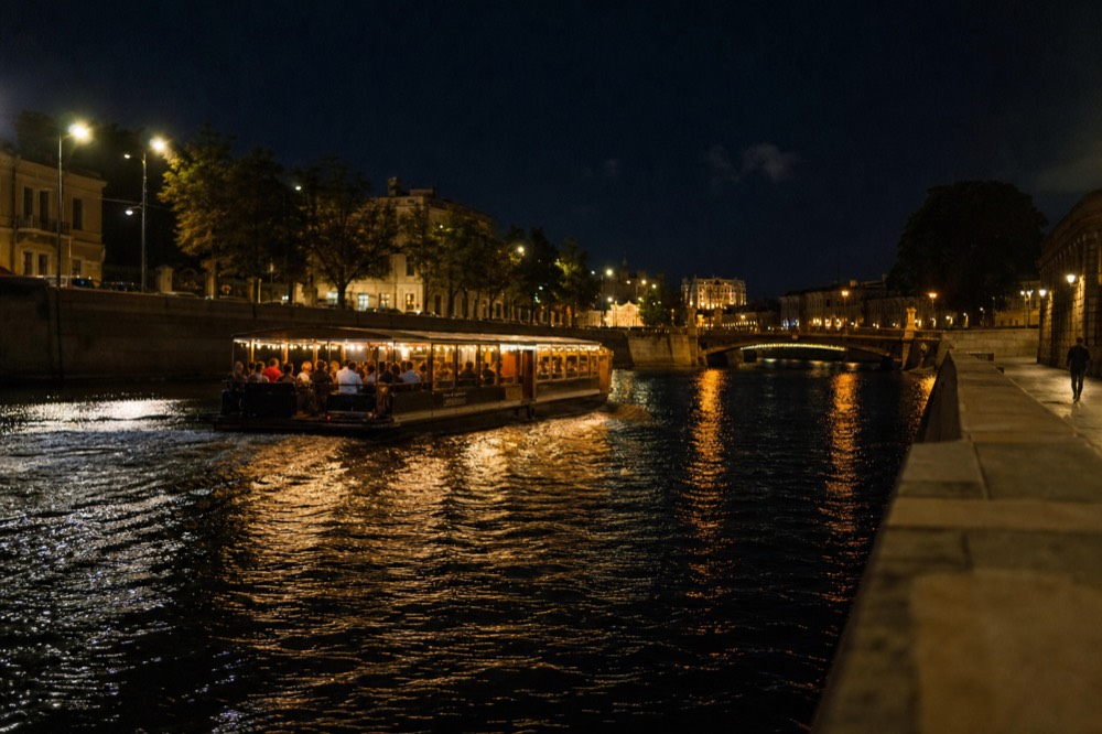An illuminated dinner cruise boat on the Seine at night, no text, no logos, no people