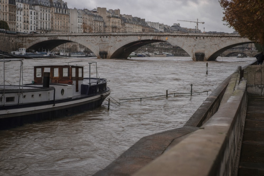 The Seine at high water flowing under a Paris bridge, no text, no logos, no people