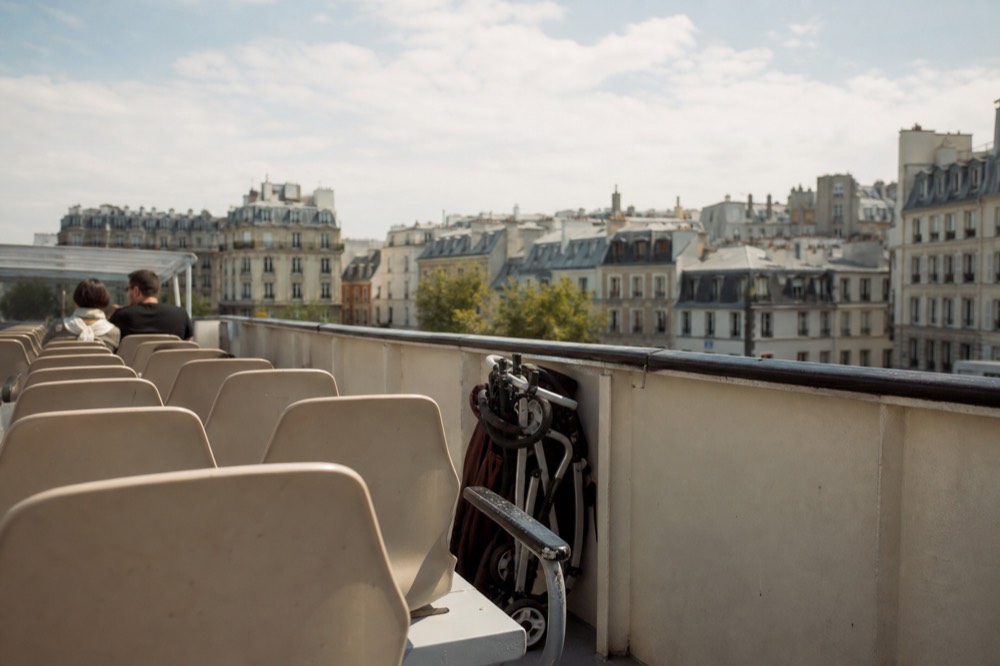 Open upper deck of a sightseeing boat on the Seine with Paris rooftops beyond, no text, no logos, no people.