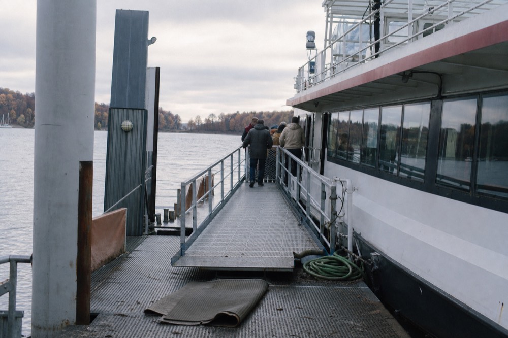 Boarding pontoon on the Seine with a ramp leading to a moored passenger boat, no text, no logos, no people.